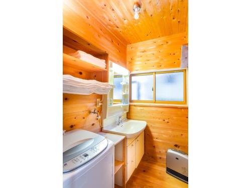 baño con cabina de madera, lavadora y secadora en Pension Eastmountain Hakuba - Vacation STAY 95920 en Hakuba
