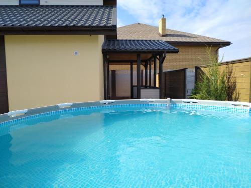 una grande piscina blu di fronte a una casa di Дом Дискавери семейный у моря! a Čornomors'k