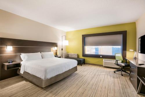 Holiday Inn Express & Suites Jacksonville - Town Center, an IHG Hotel في جاكسونفيل: غرفة فندقية بسرير وتلفزيون بشاشة مسطحة
