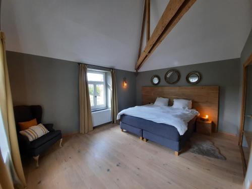 een slaapkamer met een bed, een stoel en een raam bij Cottage in Ardennes - La Maison aux Moineaux - Fays-Famenne in Sohier