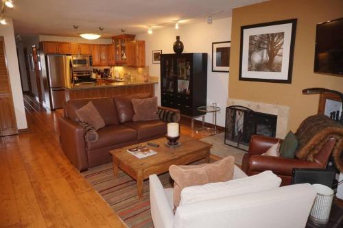 a living room with leather furniture and a fireplace at 100 Dean St E #2B in Aspen