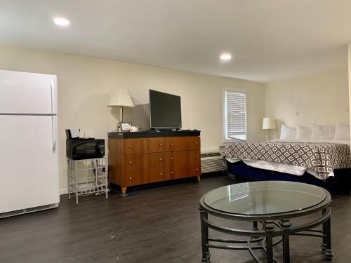 ein Wohnzimmer mit einem Sofa, einem Tisch und einem Kühlschrank in der Unterkunft Penn Lodge Hotel & Suites Philadelphia - Bensalem in Bensalem