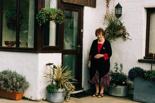 a woman standing in front of a door at The Farmhouse Lochmeyler in Llandeloy