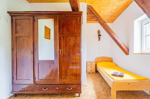 a bedroom with a wooden cabinet and a bed at Family apartments V Zátiší in Dolní Morava