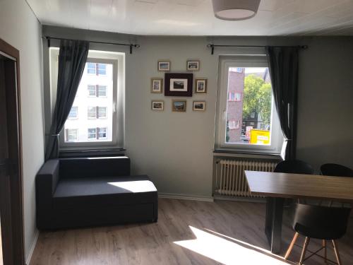 sala de estar con sofá y 2 ventanas en TM Aparts, en Dortmund