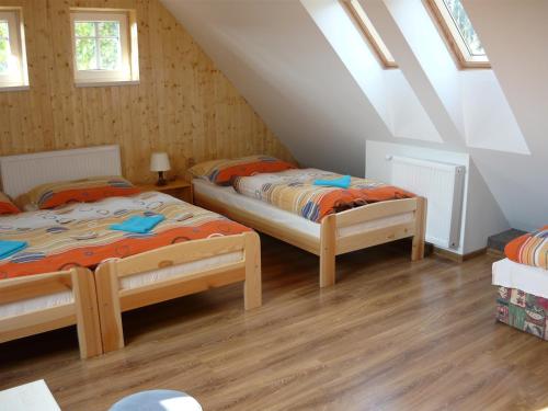 two beds in a room with a attic at Chalupa Erika in Dobšín