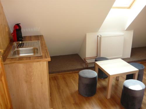 a kitchen with a sink and stools in a room at Chalupa Erika in Dobšín