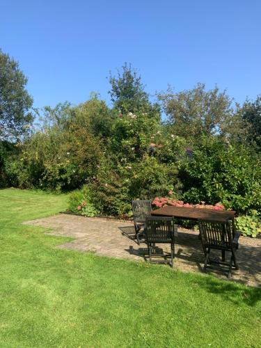 a picnic table with two chairs and flowers on it at The Hideaway at Duffryn Mawr Self Catering Cottages in Cowbridge
