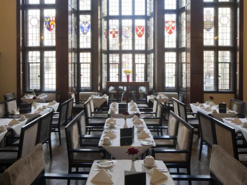 a dining room with tables and chairs and windows at Wellington Hotel by Blue Orchid in London
