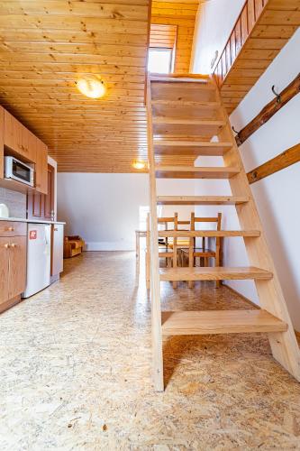 a wooden staircase in a kitchen with a table at Family apartments V Zátiší in Dolní Morava