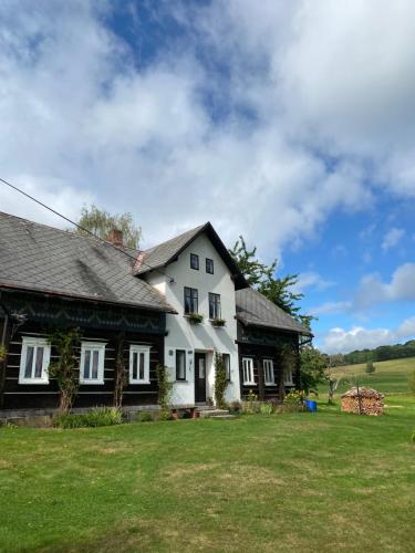 uma casa branca e preta com um jardim de relva em CHALUPA V PANSKÝM , Staré Křečany u Rumburku em Panský