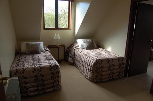 a bedroom with two beds and a window at Oak Lodge in Greymouth