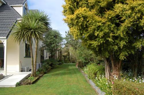 a yard of a house with trees and grass at Oak Lodge in Greymouth