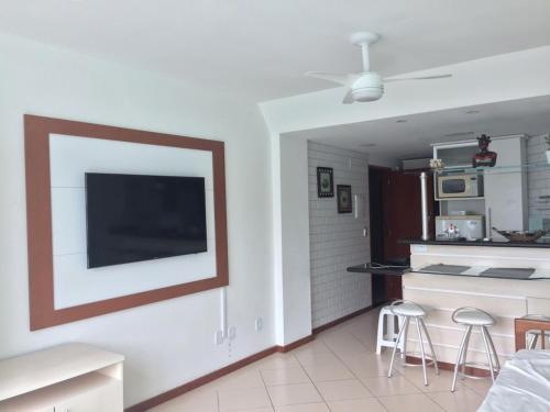 Una sala de estar con un televisor de pantalla plana en una pared. en Arraial do Cabo, Loft Visão do Paraíso, en Arraial do Cabo