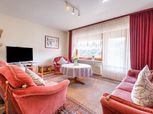 - un salon avec deux chaises et une télévision dans l'établissement Apartment with terrace in Sauerland region, à Medebach