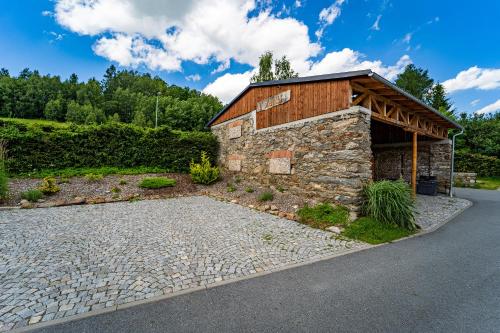 a stone building with a roof on a road at Family apartments V Zátiší in Dolní Morava