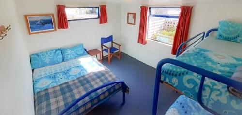 a bedroom with two bunk beds and a table at Tongariro River Retreat in Turangi