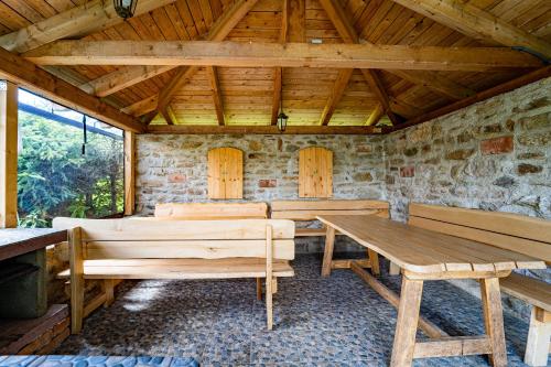 a dining room with wooden tables and benches at Family apartments V Zátiší in Dolní Morava