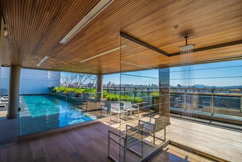 ein Haus mit Swimmingpool und Glaswänden in der Unterkunft 360 República in São Paulo