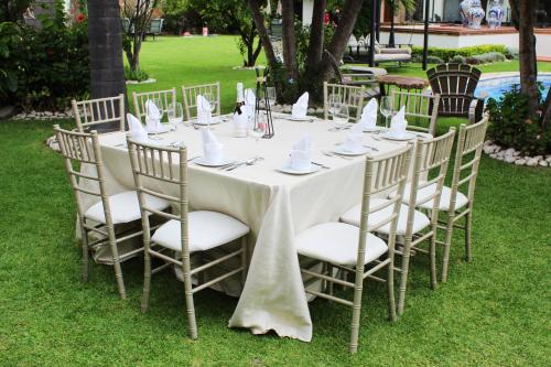 a long white table with chairs and napkins on it at Hotel Boutique La Rioja in Atlixco