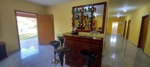 a room with a bar with stools and a mirror at Pousada Chácara Sonho in Hortolândia