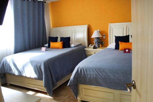 two beds sitting next to each other in a bedroom at Hotel Boutique La Rioja in Atlixco