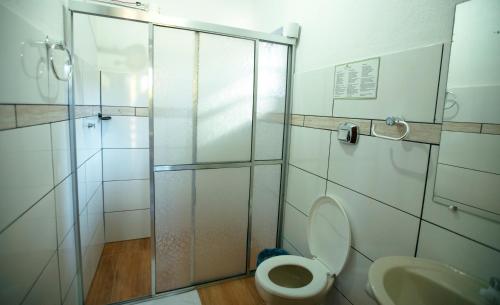 a bathroom with a shower and a toilet and a sink at Pousada São Chico Eco Village in São Francisco de Paula