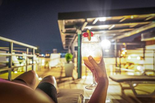 a person holding up a drink with a strawberry on it at Casa Amanzi Cartagena by Bernalo Hotels in Cartagena de Indias