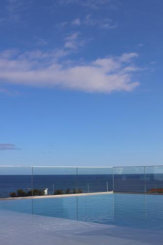 a swimming pool with a view of the ocean at Three House Hotel in Funchal