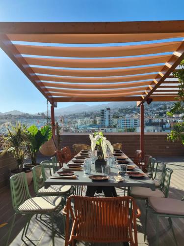 a long table on a patio with a view of the city at Three House Hotel in Funchal