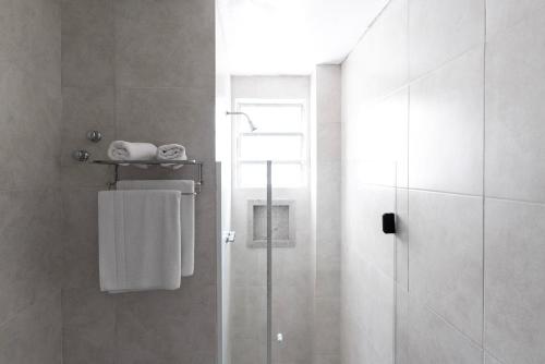 uma casa de banho com um chuveiro e uma porta de vidro em Hotel Fabris em Nova Friburgo