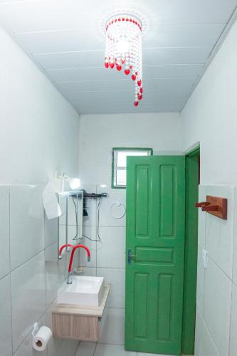a bathroom with a green door and a green door at Pousada Estrela do Oriente in Taíba