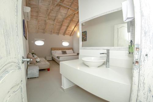 a white bathroom with a sink and a living room at Casa Amanzi Hotel Cartagena in Cartagena de Indias