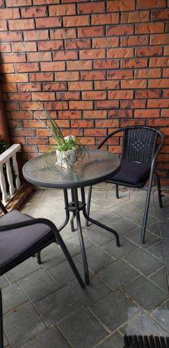 uma mesa e duas cadeiras e uma parede de tijolos em Ballymena em Carterton
