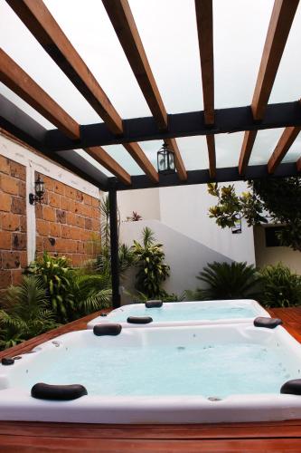 a hot tub in a patio with a roof at Hotel Boutique La Rioja in Atlixco