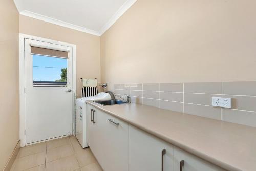a white kitchen with a sink and a counter at Kennedy Holiday Villas in Mulwala