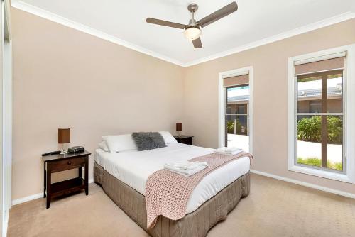 a bedroom with a bed and a ceiling fan at Kennedy Holiday Villas in Mulwala