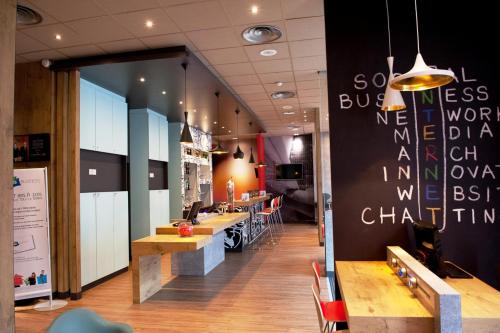a restaurant with a long row of tables and chairs at Ibis Agen Centre Gare in Agen