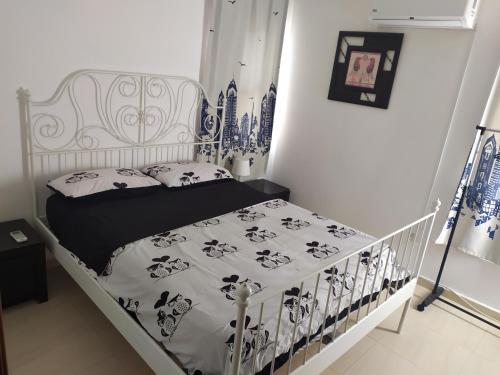a bedroom with a bed with a black and white comforter at Lake House in Tiberias