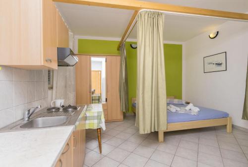 eine Küche mit einem Bett in der Ecke eines Zimmers in der Unterkunft Apartments Mirko in Lokva Rogoznica