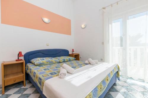 una camera da letto con un letto blu e una finestra di Apartments Mirko a Lokva Rogoznica