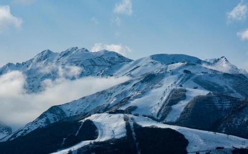 a mountain covered in snow and clouds in front at 白馬パウダーマウンテン in Hakuba