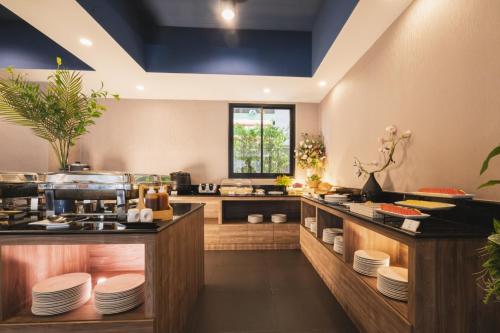 a kitchen with a counter with plates on it at The Home Hotel SHA in Bangkok