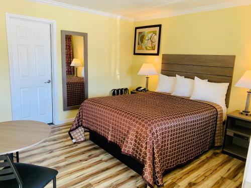 ein Hotelzimmer mit einem Bett und einem Tisch in der Unterkunft Central Coast Inn in Cayucos