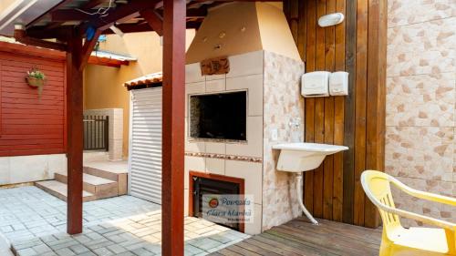 a outdoor fireplace with a sink on a deck at Pousada Clara Manhã in Bombinhas