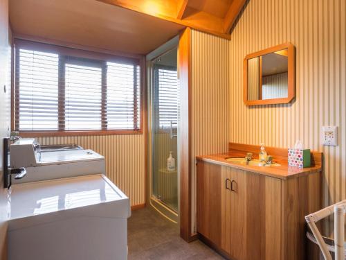 a bathroom with a sink and a mirror at Evergreen Haven - Queenstown Holiday Home in Queenstown