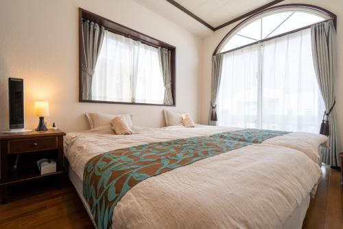 a bedroom with a large bed and a window at with-terrace (Umi) in Kohama