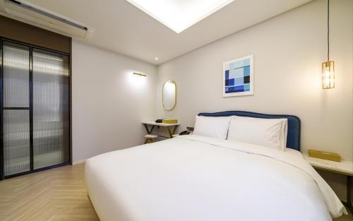 a bedroom with a large white bed and a window at GijangYeonhwari No,25 Hotel in Busan