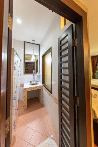 a hallway leading to a bathroom with a sink at The RiverKwai Bridge Resort in Kanchanaburi City
