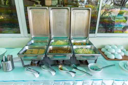 een buffet met dienbladen eten op tafel bij The RiverKwai Bridge Resort in Kanchanaburi